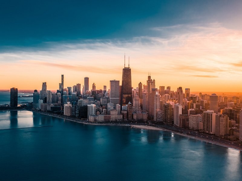 The skyline and the lakefront from above as the sun sets behind the towers